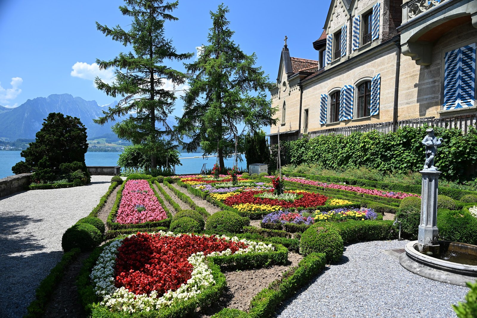 Parterre de flores do Castelo de Oberhofen descendo ate o Lago Thun, com a montanha Niesen ao fundo