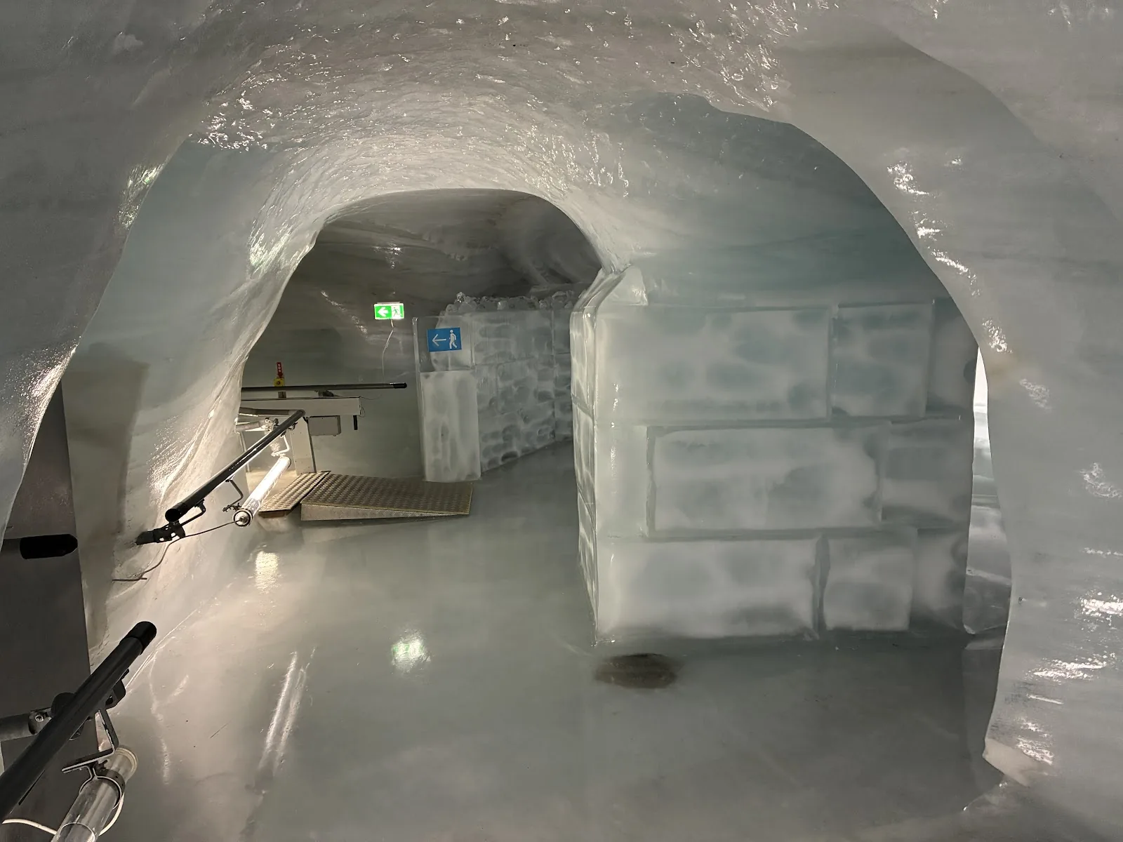 Corredor do Palácio de Gelo do Jungfraujoch, com paredes curvas de gelo e corrimão