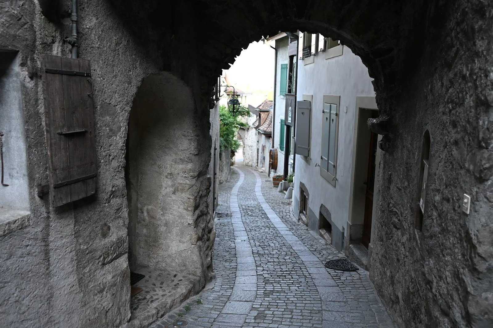 Viela de pedra entre casas em Lavaux, vista através de uma passagem em arco