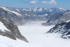 Faixas escuras de morenas no gelo de Aletsch entre encostas rochosas, vistas do Jungfraujoch