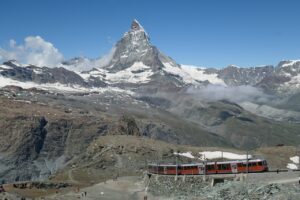 Trem do Gornergrat diante do Matterhorn, com rochas e neve na paisagem alpina