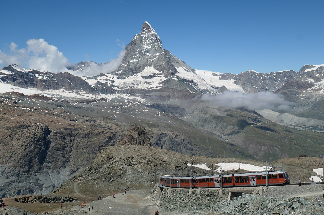 Trem do Gornergrat diante do Matterhorn, com rochas e neve na paisagem alpina