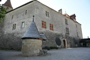 Pátio de pedra do Castelo de Gruyères, com poço e fachada medieval