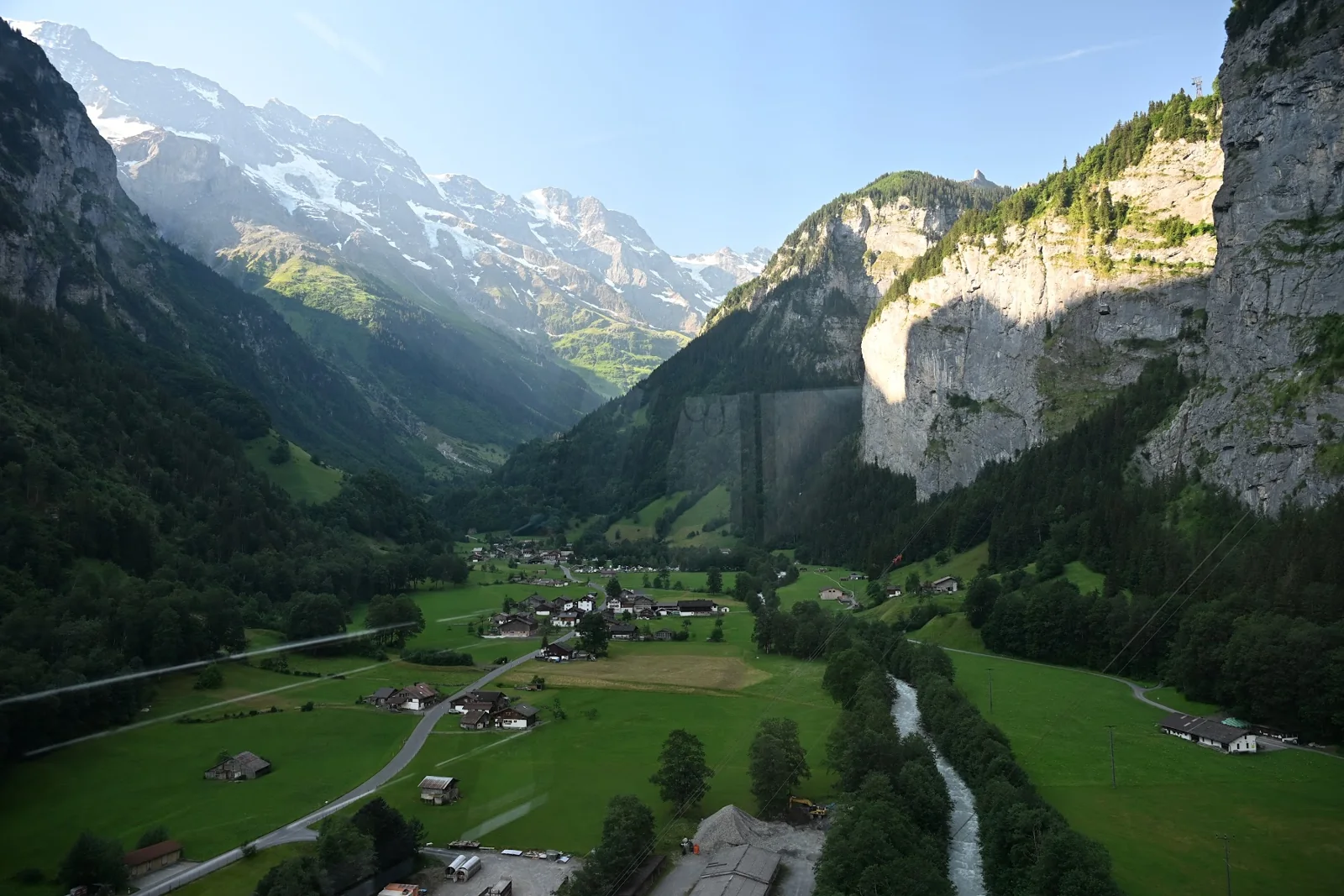 Vale de Lauterbrunnen com campos, rio e encostas rochosas