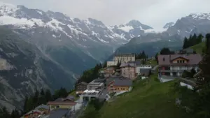 Casas de Mürren na encosta, com paredões e montanhas nevadas ao fundo