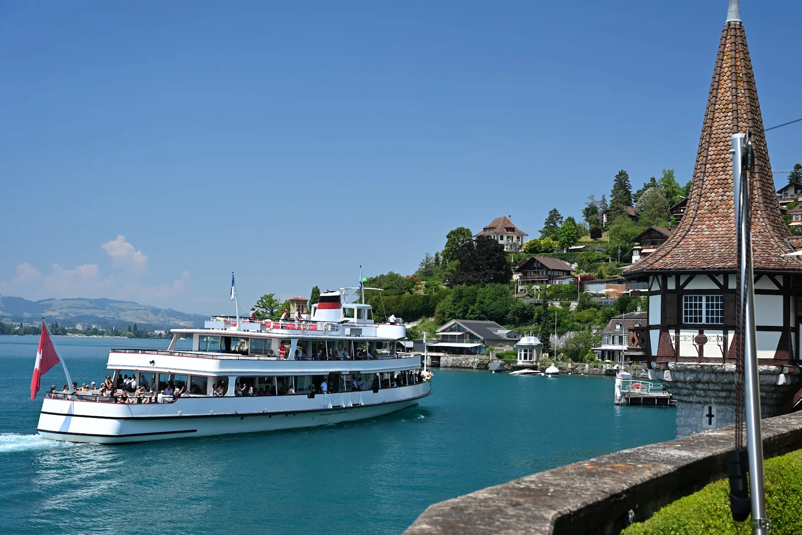 Barco de passageiros no Lago Thun junto à torre do Castelo de Oberhofen