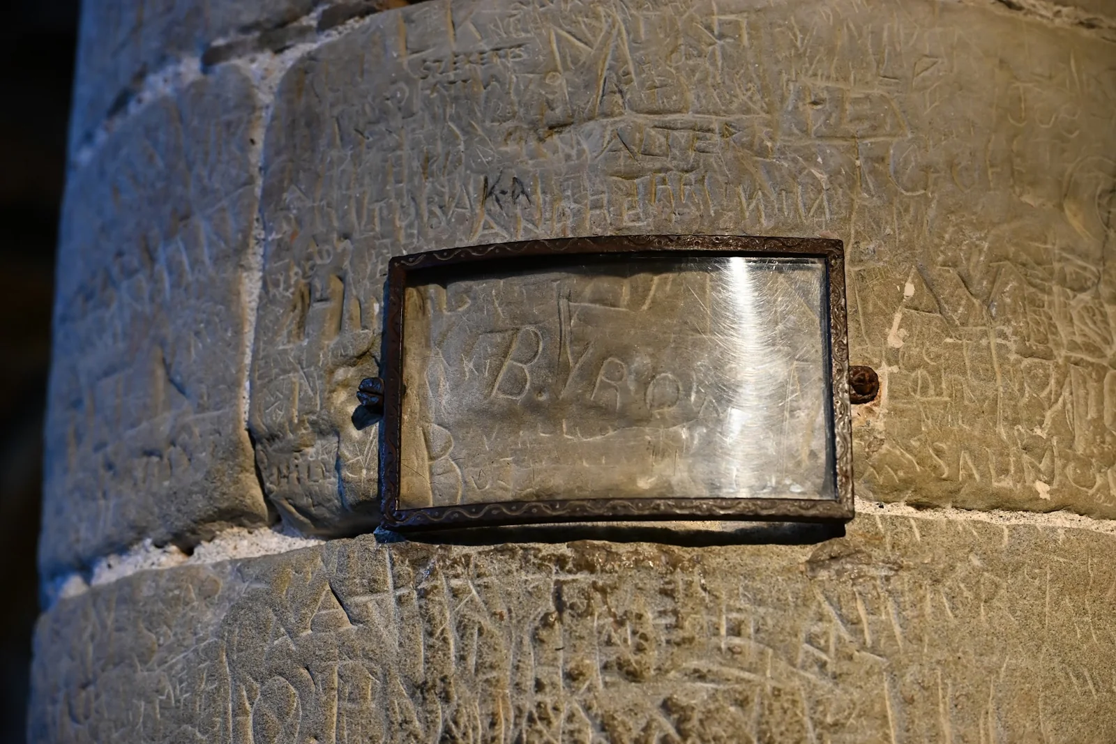 A inscrição de Byron protegida por vidro em uma coluna da masmorra de Chillon