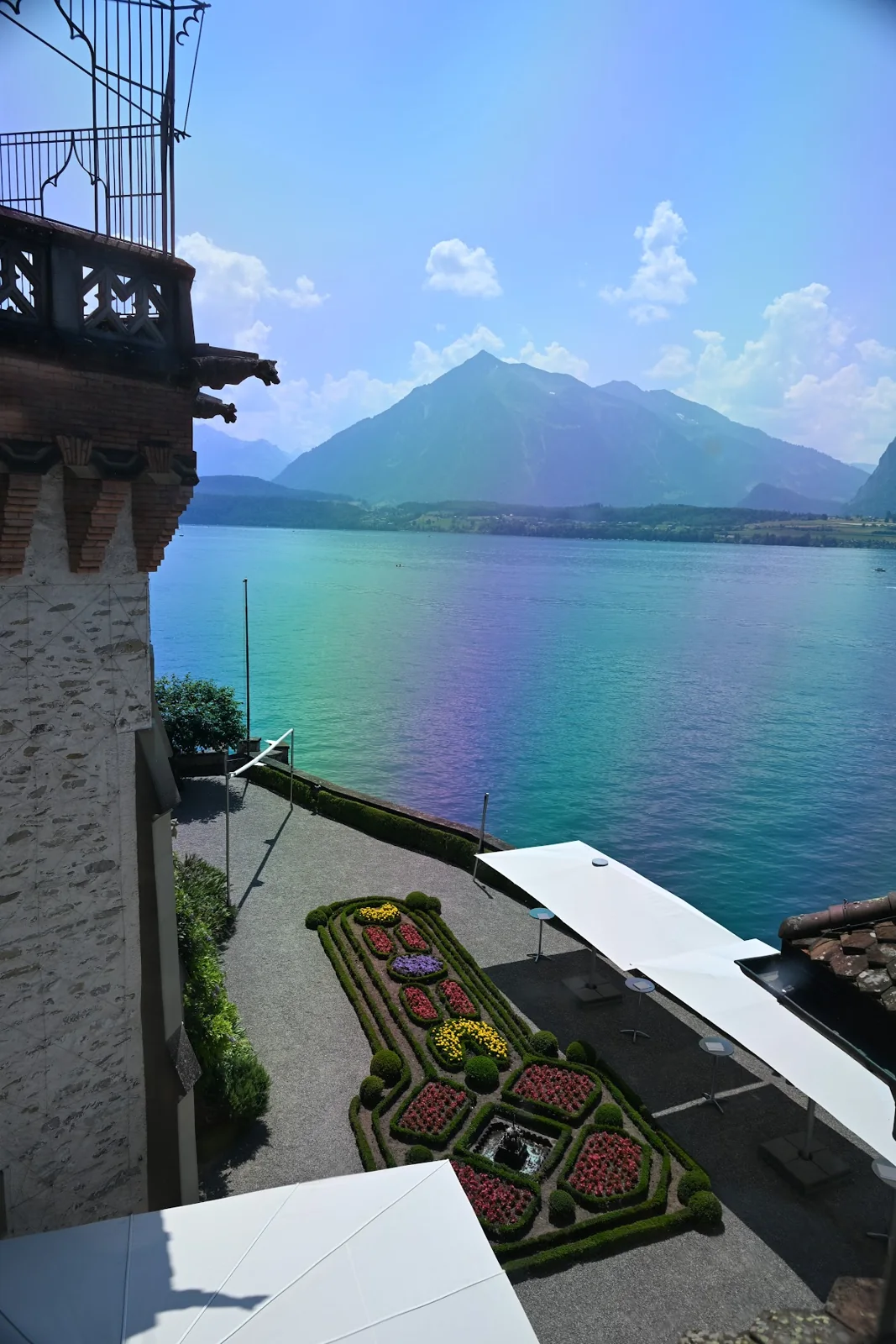 O Lago Thun e os canteiros de Oberhofen vistos de uma janela do castelo