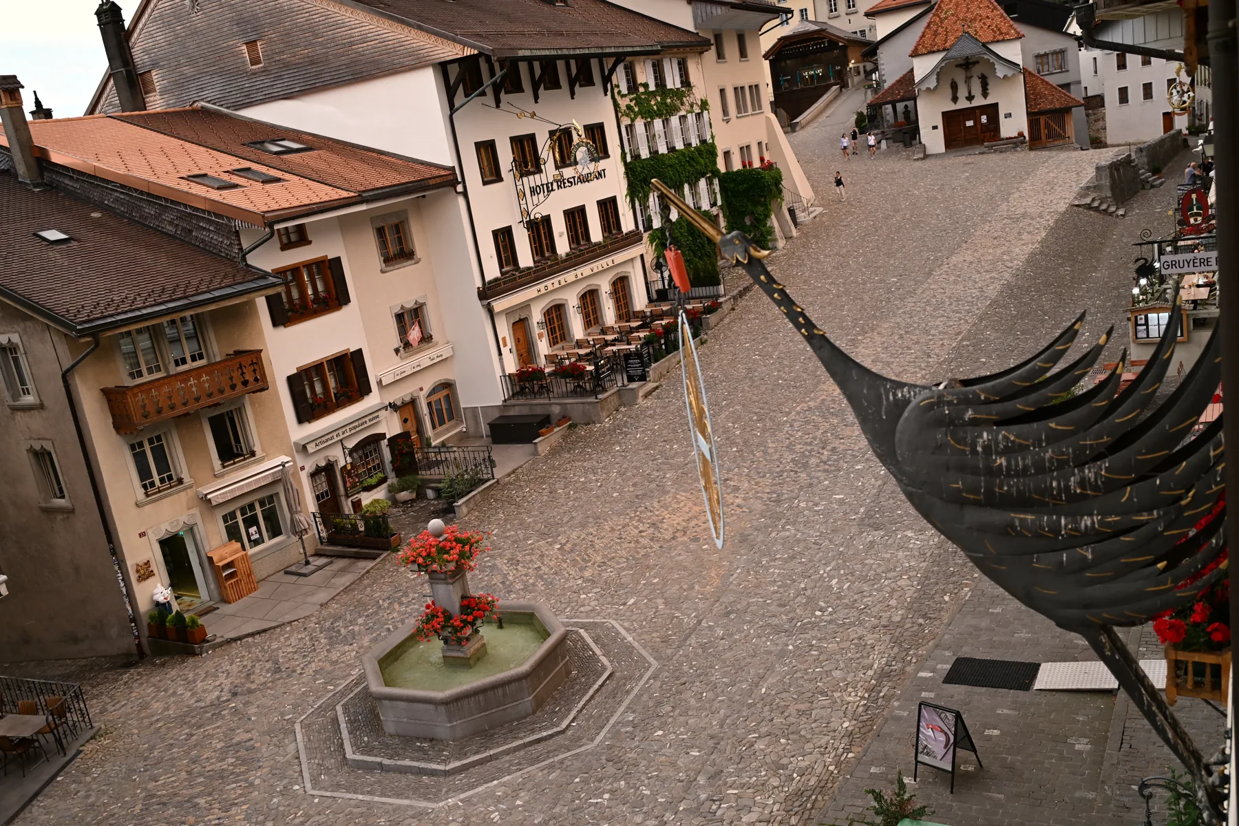 Vista elevada da rua de pedra e das fachadas da vila de Gruyères