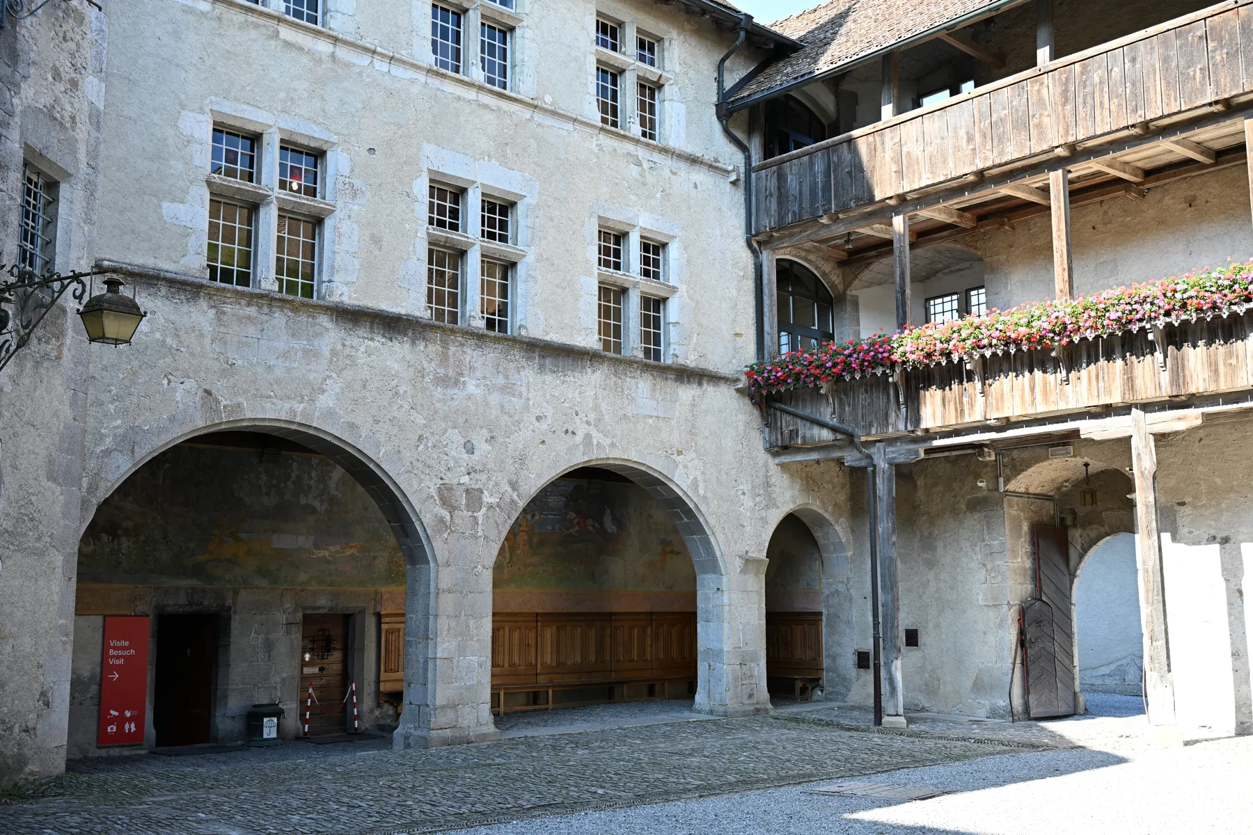 Arcos e galeria com floreiras no pátio do Castelo de Gruyères