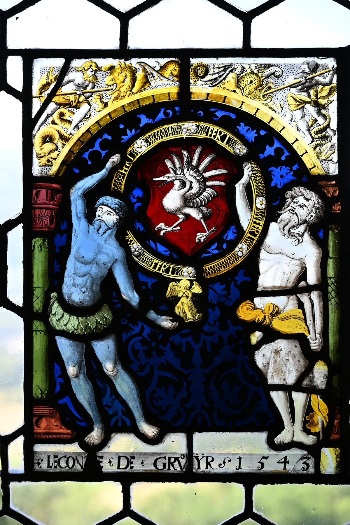Vitral do castelo com figuras, escudo vermelho e a inscrição 1543