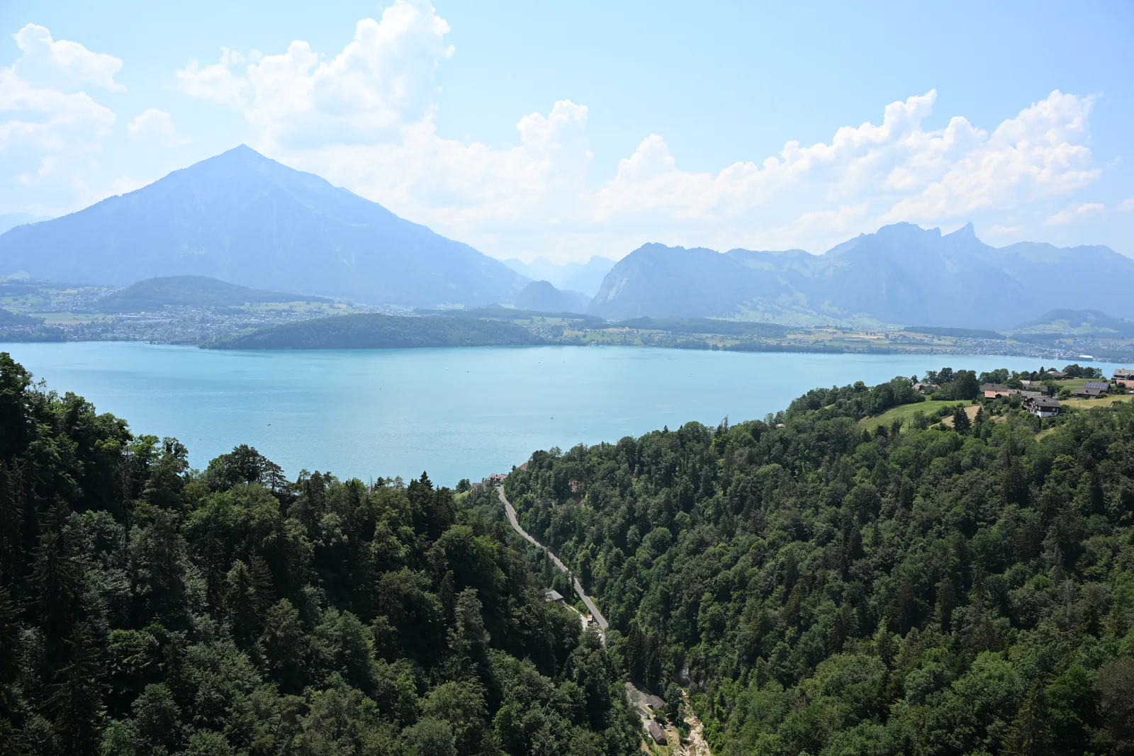 Lago Thun e montanhas vistos acima da garganta arborizada de Sigriswil