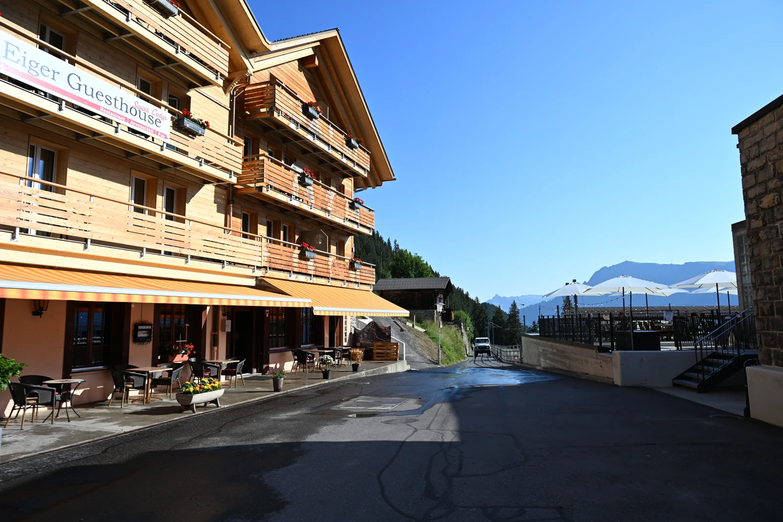 Rua de Mürren com fachada de madeira, piso pavimentado e escadas junto aos edifícios