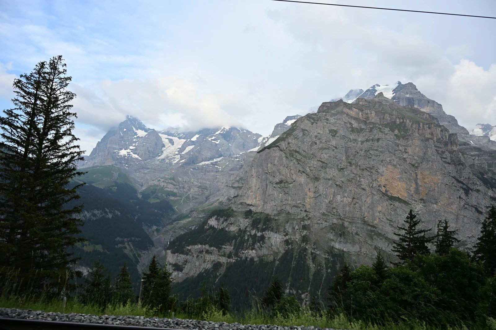 Montanhas e encosta arborizada vistas no acesso à região de Mürren