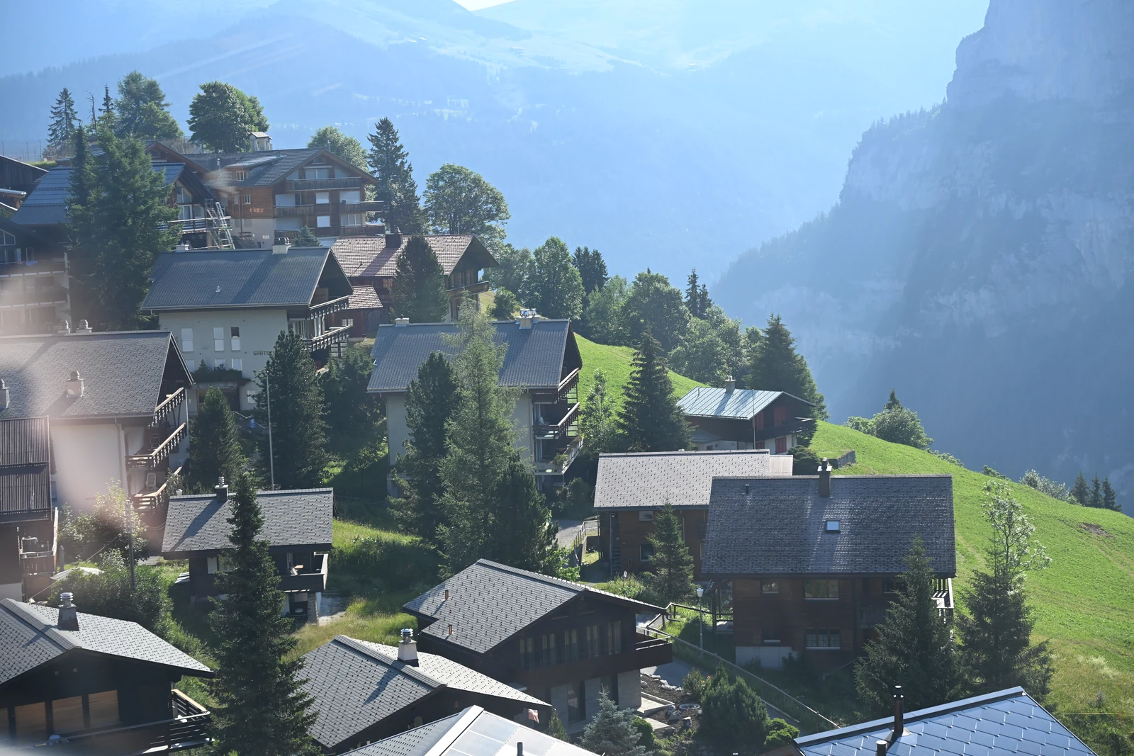 Casas e prados de Mürren vistos de cima com a parede do vale ao fundo