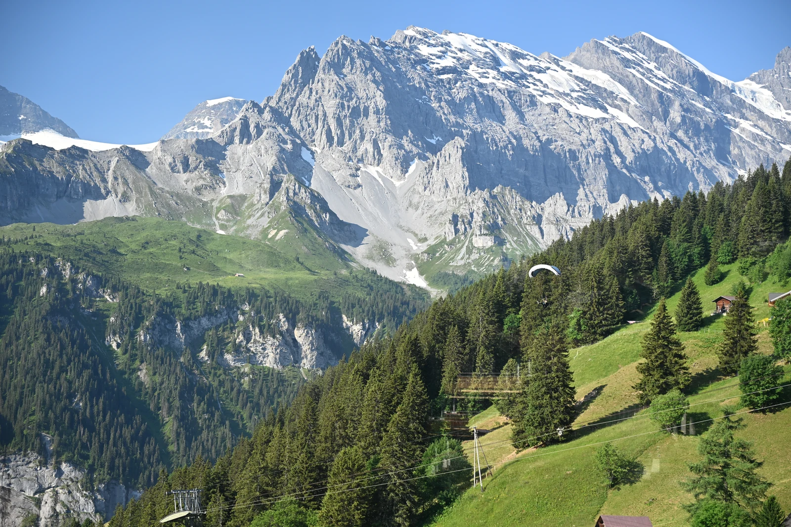 Montanhas, encosta verde e parapente sobre a região de Mürren
