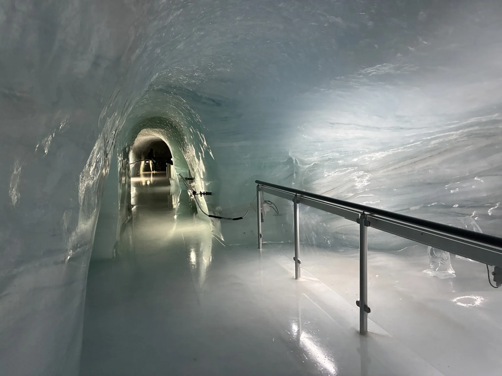 Curva entre túneis de gelo com corrimão no Palácio de Gelo do Jungfraujoch
