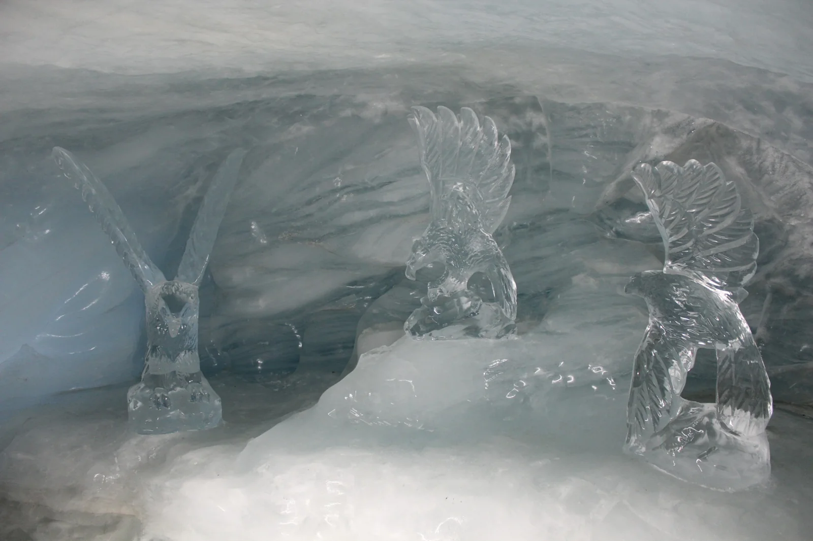 Três aves de asas abertas esculpidas em gelo no Palácio de Gelo do Jungfraujoch