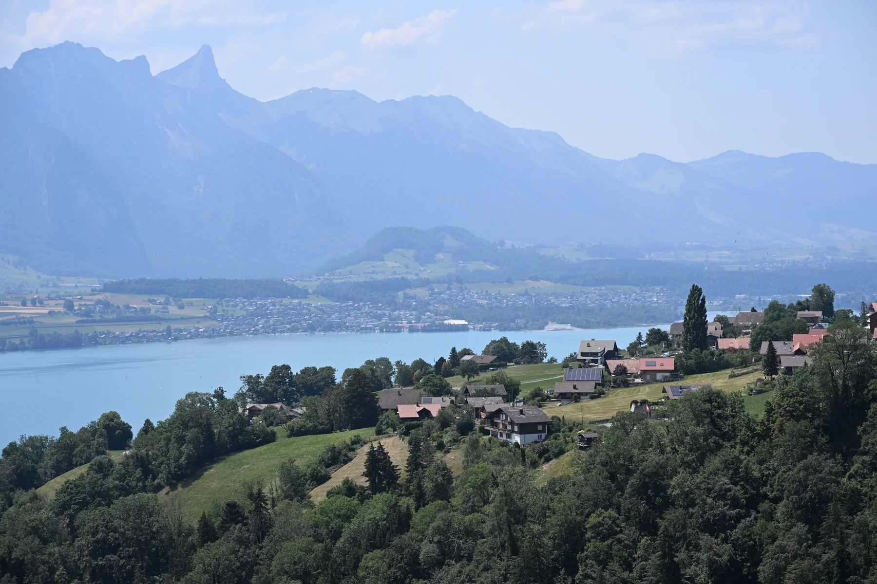 Casas nas encostas e Lago Thun vistos da ponte de Sigriswil