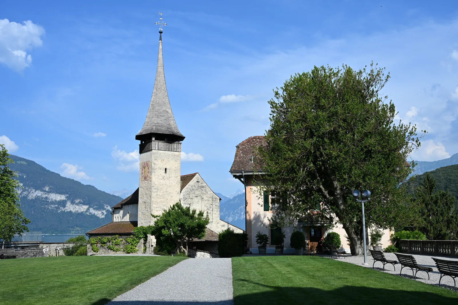 Igreja de Spiez ao lado dos caminhos e bancos do conjunto do castelo
