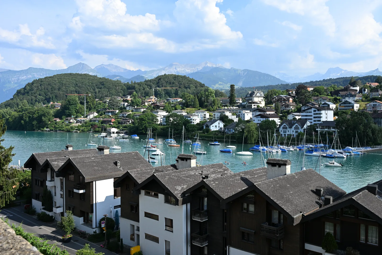 Baía de Spiez com veleiros, casas e montanhas ao fundo, vista de cima