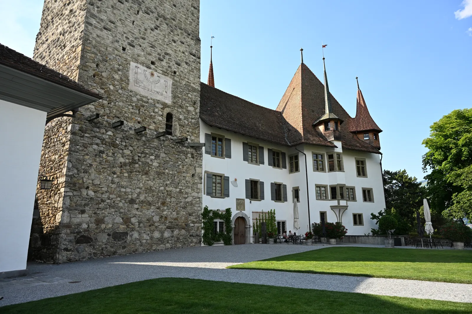 Fachada do castelo antigo junto à torre, com janelas, portas e relógio de sol