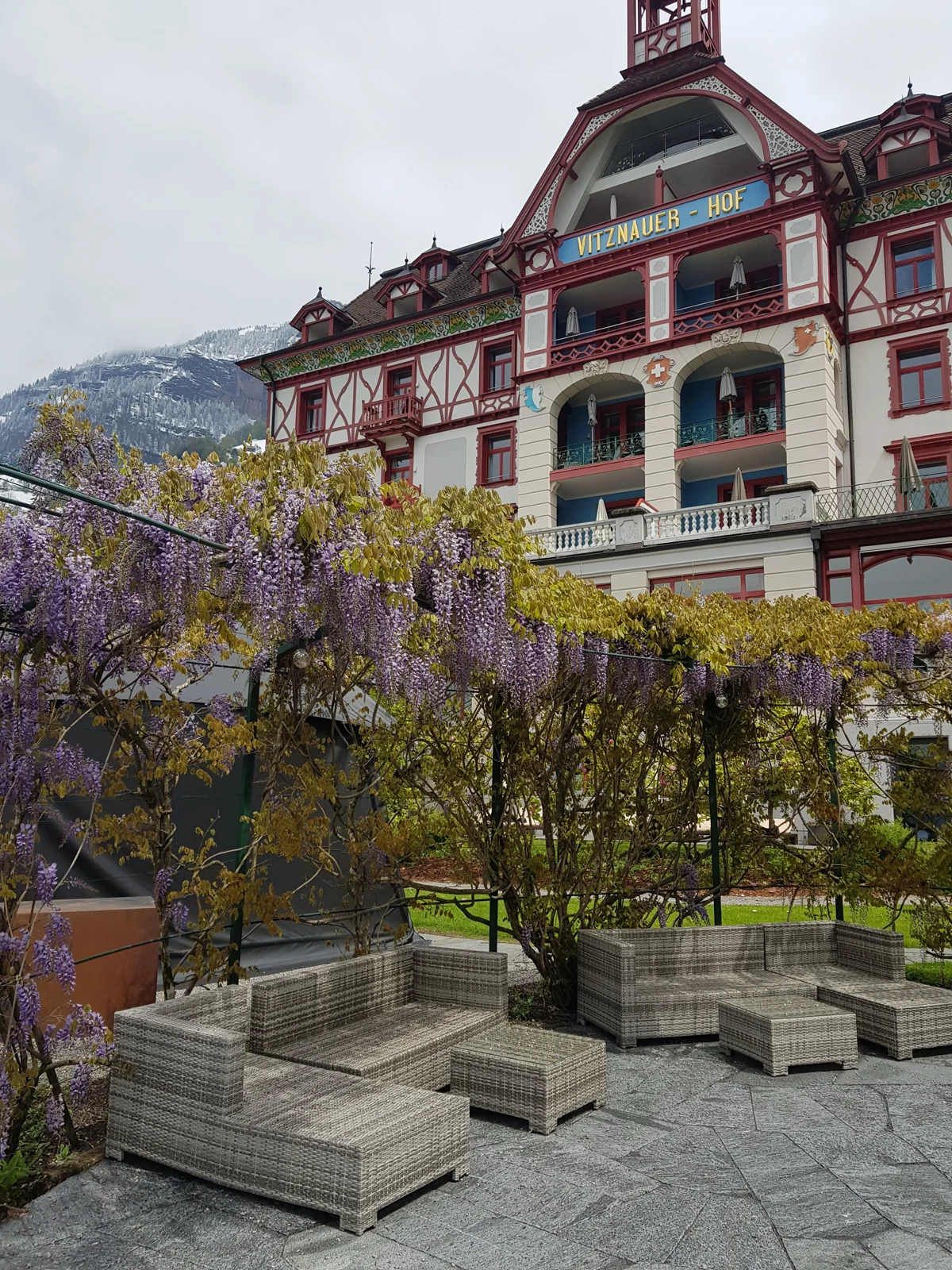 Fachada do Vitznauerhof, em Vitznau, com glicínias no jardim.